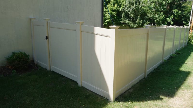 White vinyl fences with door to backyard.